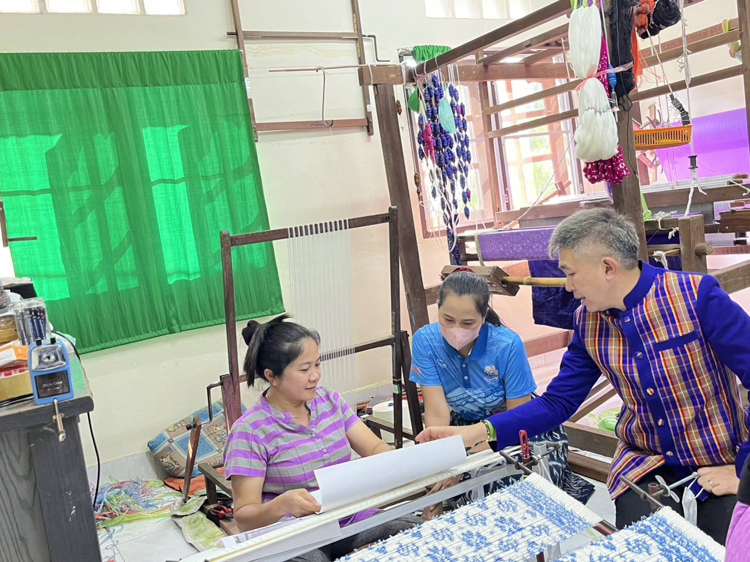 พช.กาญจนบุรี ลงพื้นที่ติดตาม เยี่ยมเยียน และให้กำลังใจ ช่างทอผ้า ในการทอผ้าลายดอกรักราชกัญญา เพื่อเตรียมเข้าประกวดผ้าลายพระราชทาน “ผ้าลายดอกรักราชกัญญา”