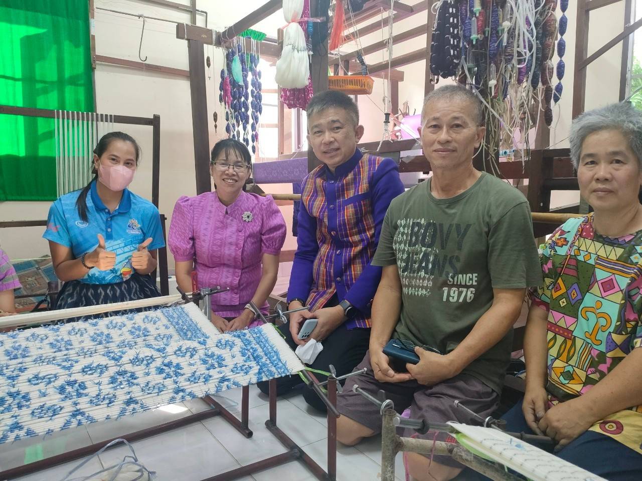 พช.กาญจนบุรี ลงพื้นที่ติดตาม เยี่ยมเยียน และให้กำลังใจ ช่างทอผ้า ในการทอผ้าลายดอกรักราชกัญญา เพื่อเตรียมเข้าประกวดผ้าลายพระราชทาน “ผ้าลายดอกรักราชกัญญา”
