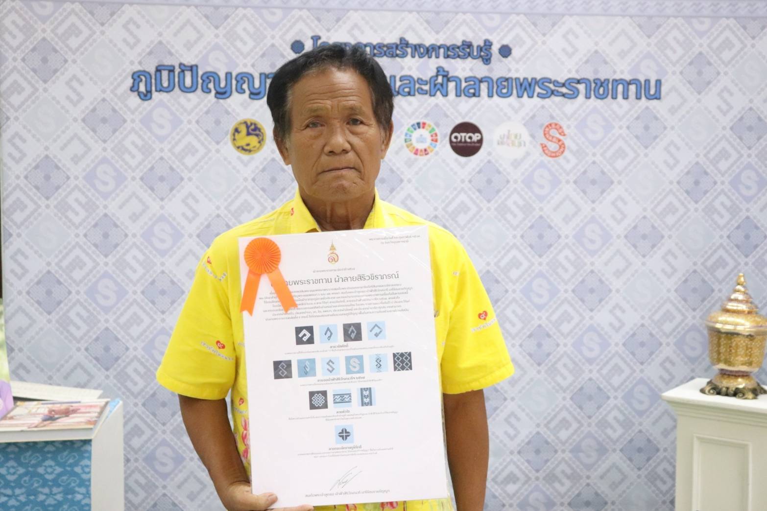 จังหวัดกาญจนบุรี จัดพิธีมอบแบบลายผ้าพระราชทาน “ผ้าลายสิริวชิราภรณ์” “ผ้าลายชบาปัตตานี” และเครื่องหมายรับรองสินค้าแฟชั่นและหัตถกรรมพระราชทาน “Sustainable Fashion: แฟชั่นแห่งความยั่งยืน” ให้กับช่างทอผ้าทุกกลุ่ม ทุกเทคนิค เพื่อพัฒนาคุณภาพชีวิตประชาชนอย่างยั่งยืน
